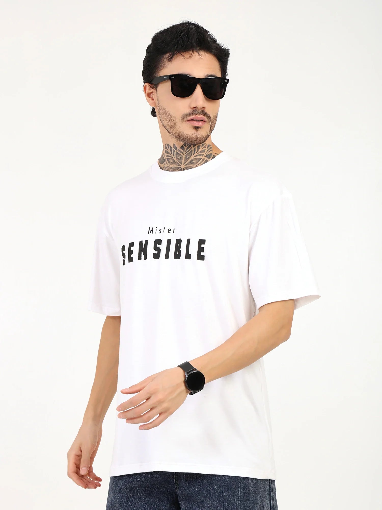 Men's oversized white t-shirt with 'Mister SENSITIVE' print, styled with sunglasses and casual jeans.