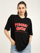 Woman wearing a black t-shirt with red text on a plain background